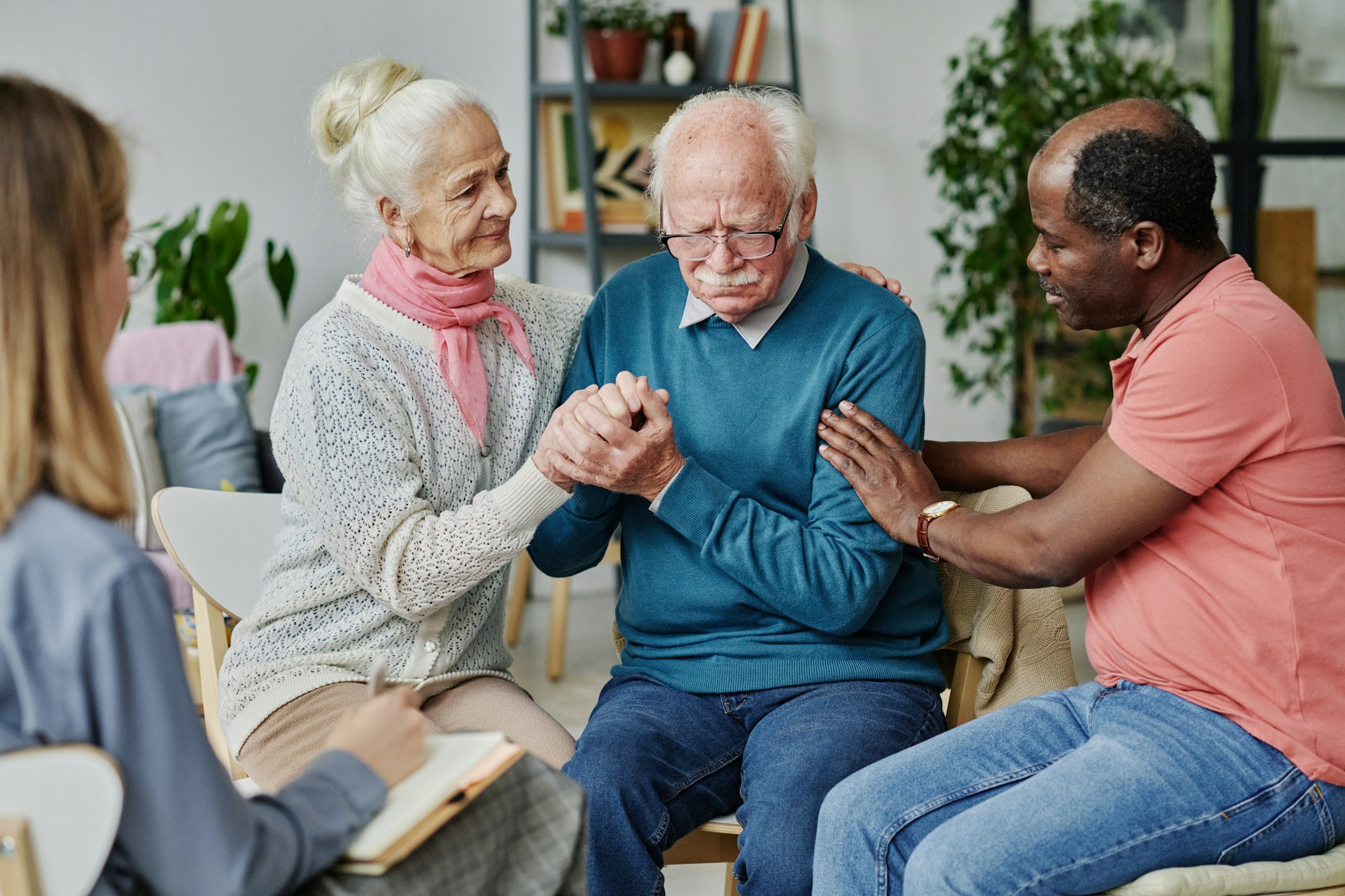 People supporting senior man at session